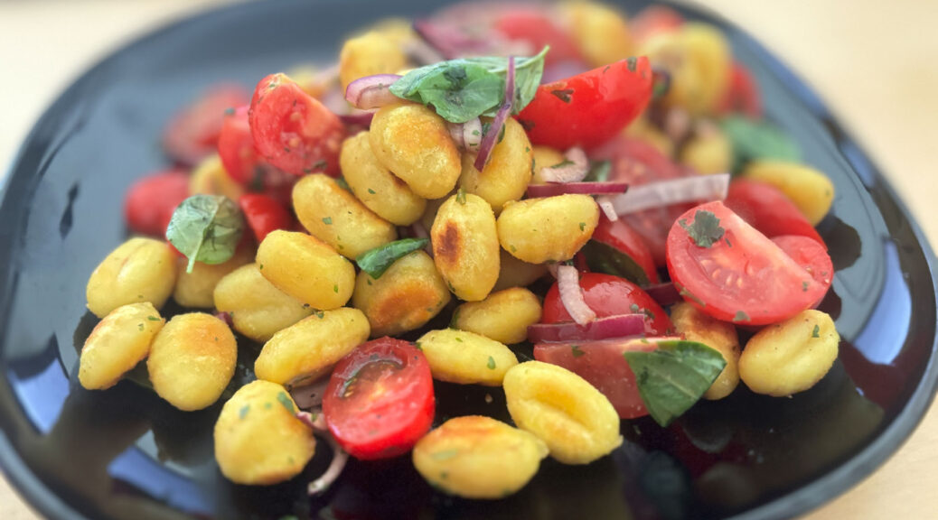 Salat mit knusprigen Gnocchi,Tomate und roten Zwiebeln